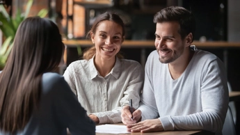 Happy customers couple ready to sign bank loan agreement meeting broker agent